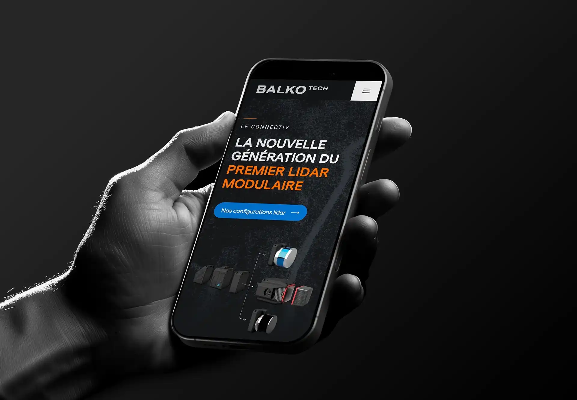 Main tenant un téléphone qui affiche l'accueil du site Balko Technologies.