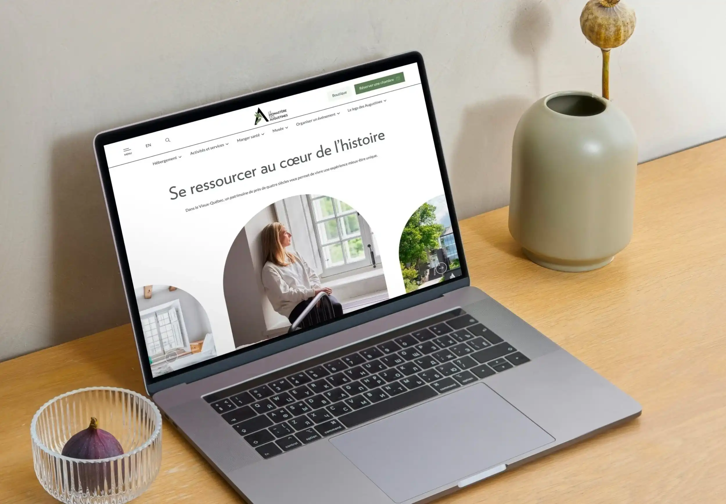 Ordinateur portable sur un bureau à côté d'un vase, montrant l'accueil du site du Monastère des augustines